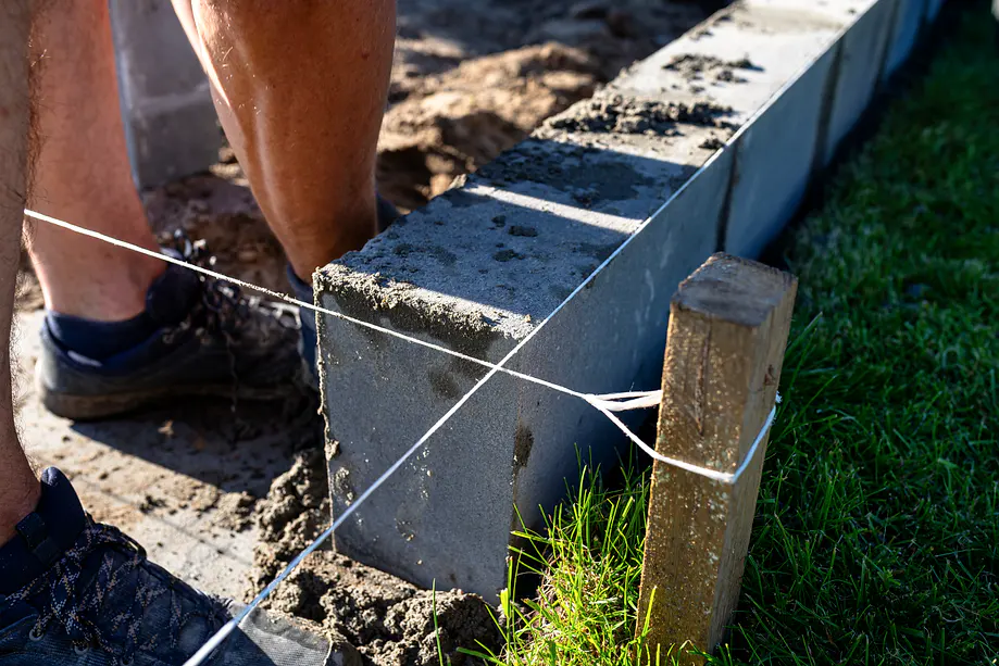 Builders setting out concrete blockwork for a house extension